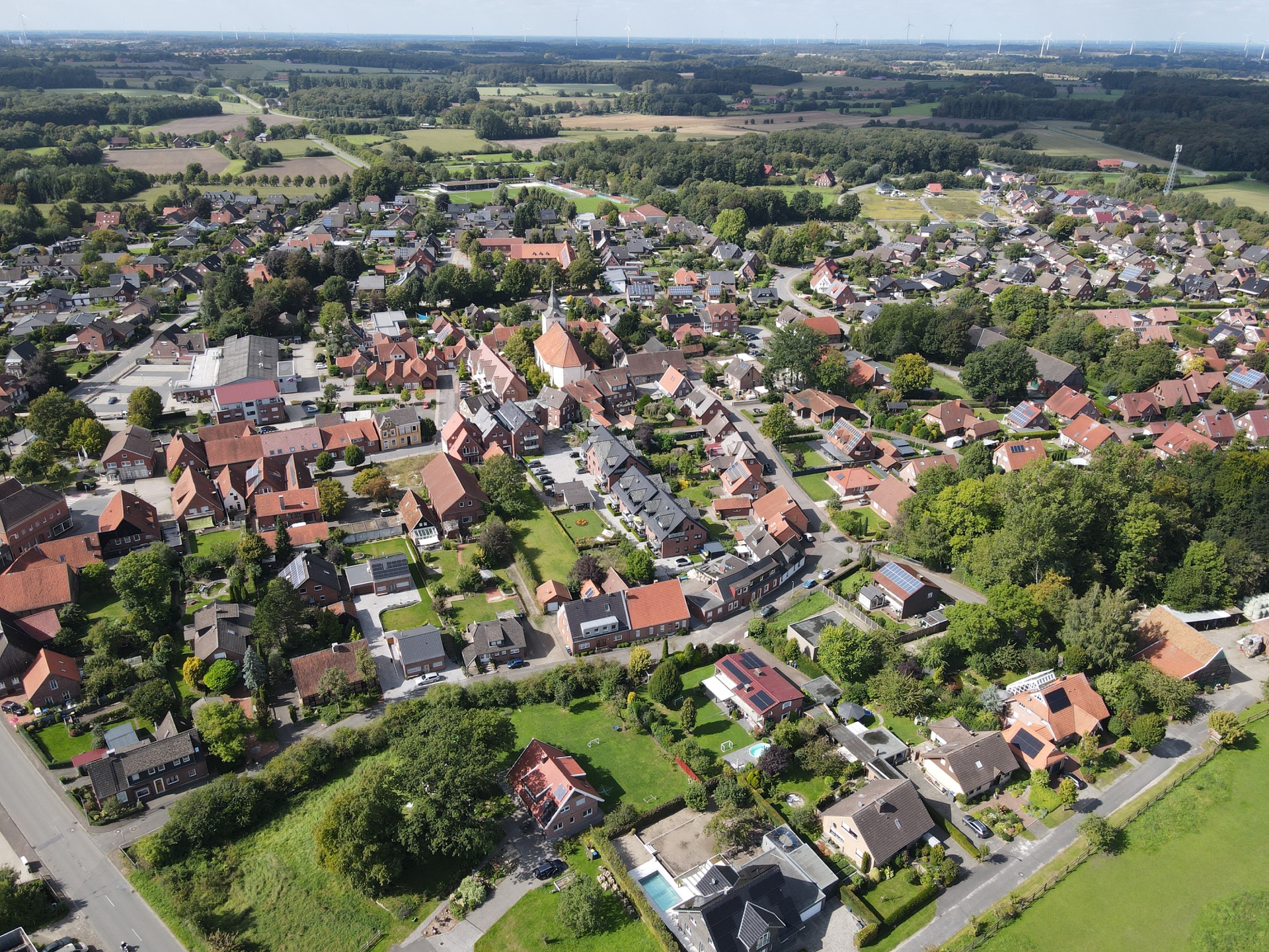 Luftaufnahme einer Ortschaft mit Wohnhäusern und grüner Umgebung aus dem DIM-Bildbestand